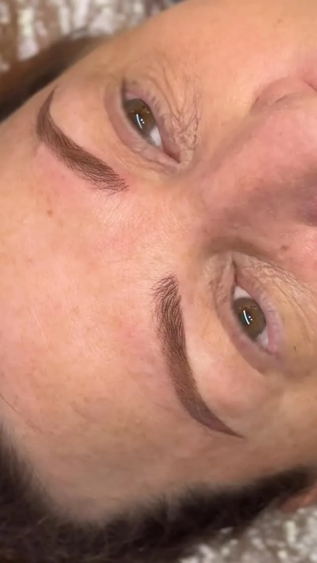 Mature client showing healed cosmetic brow tattoo with open eyes