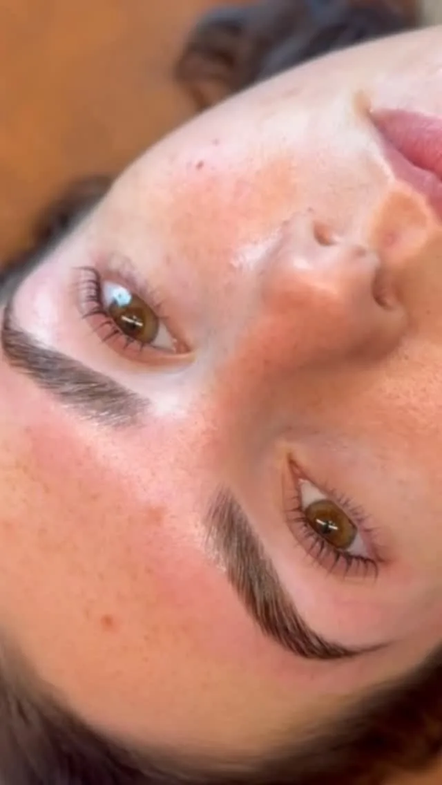 Client's finished brow and lifted lashes in warm indoor light — healed result