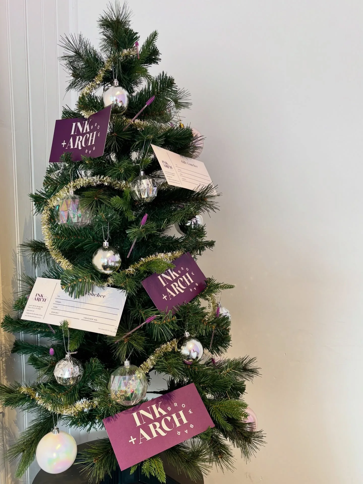 Ink & Arch gift voucher cards displayed among festive decorations