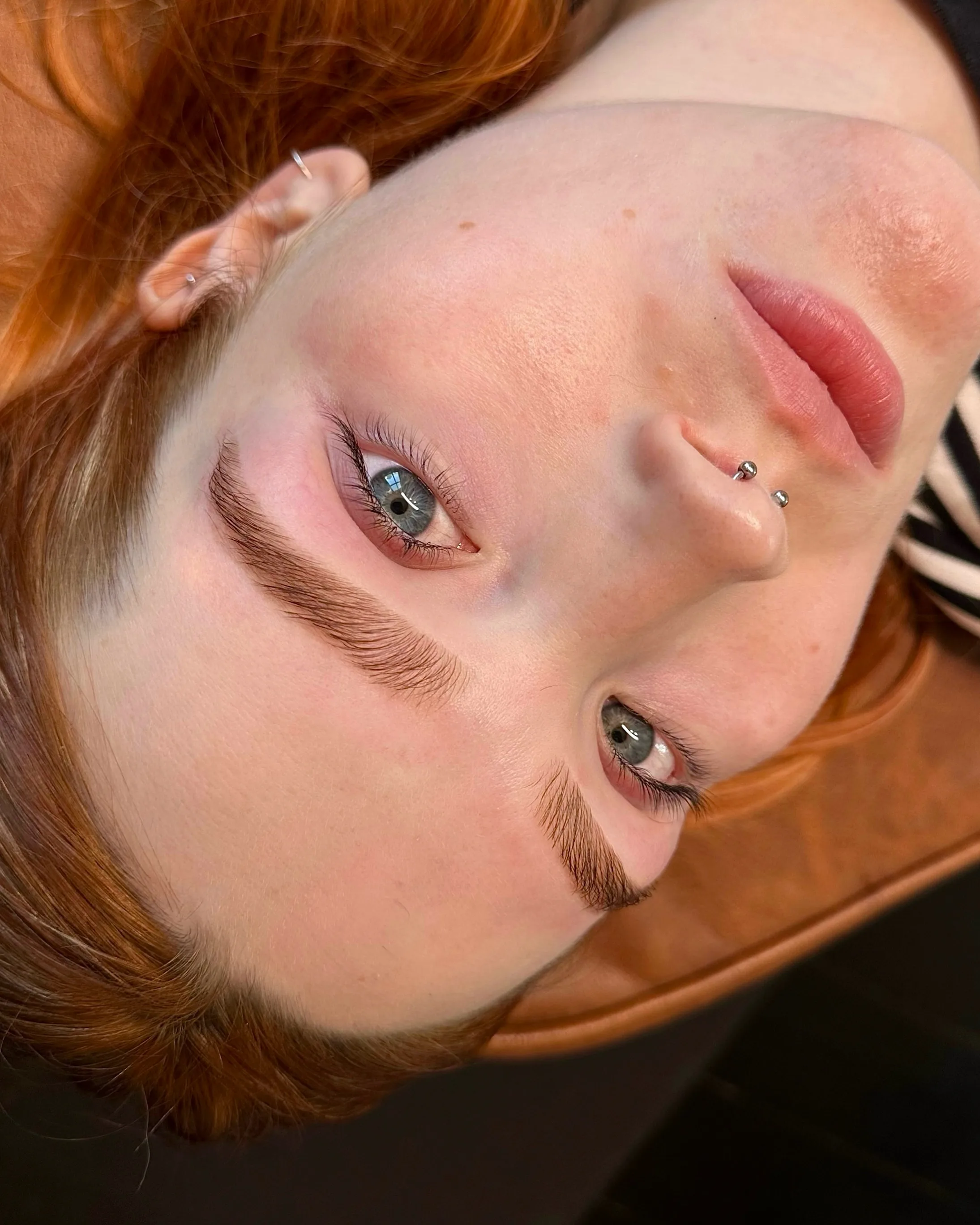 Red-haired client with healed lip blush and shaped brows, freckles