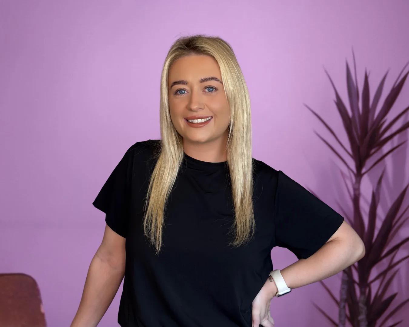 Studio portrait of a team member at Ink & Arch Brow Bar on an orchid backdrop